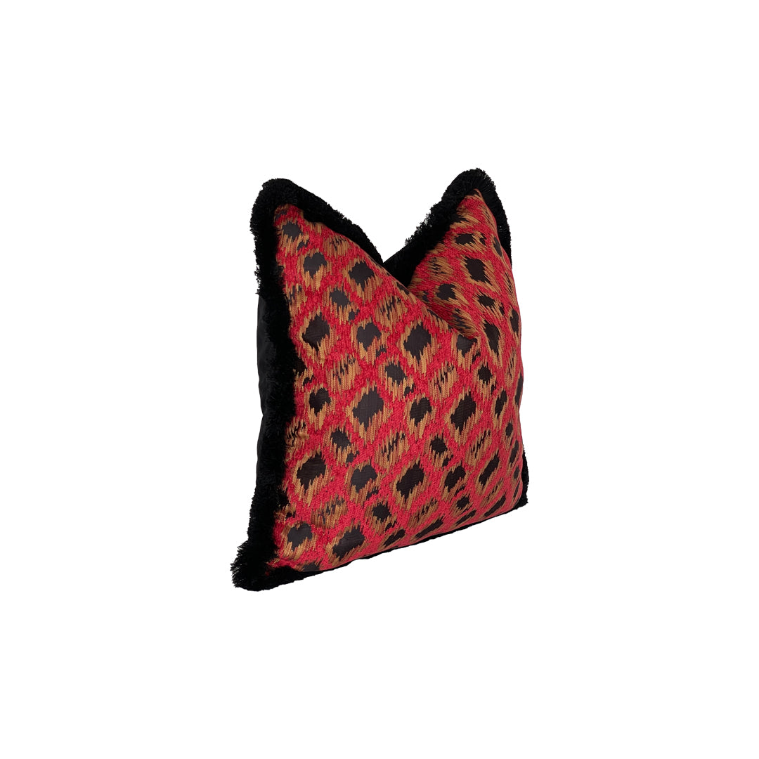 Square pillow with roba de lléngos 'cloth of the Tongues' ikat print with red back and black and amber blur and breed, Finished with black brush fringe. 