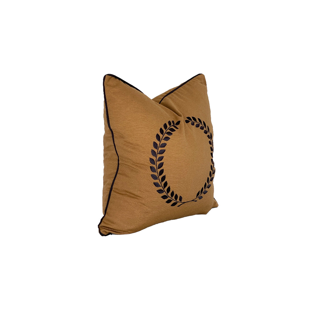 side image caramel gold square pillow with black handwork wreath